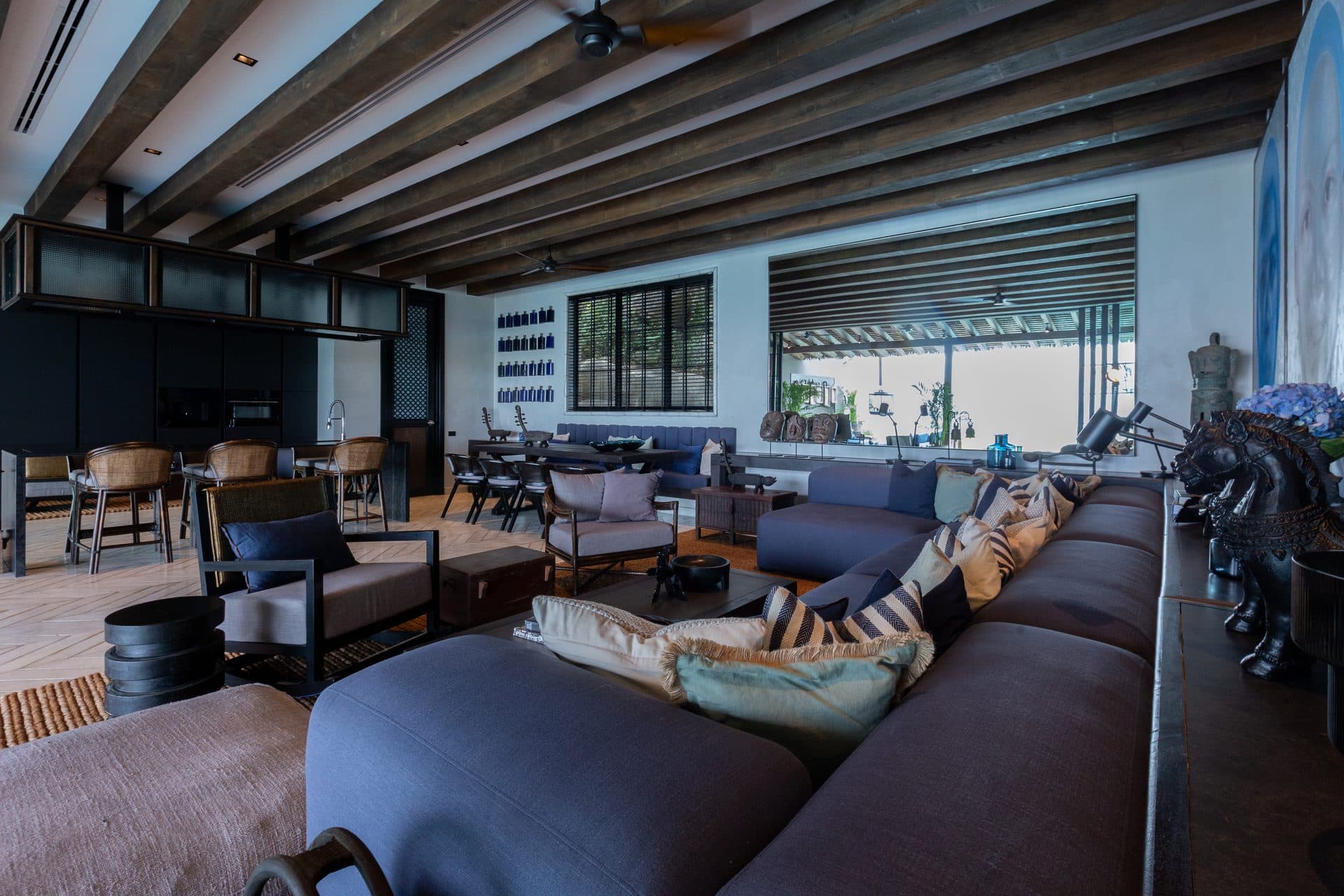 Double-height living space wrapped in full-height glass at dusk